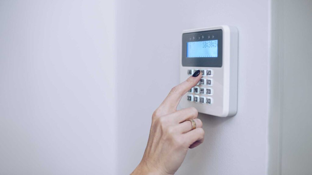 Femme qui met son code pour déverrouiller son système d’alarme 