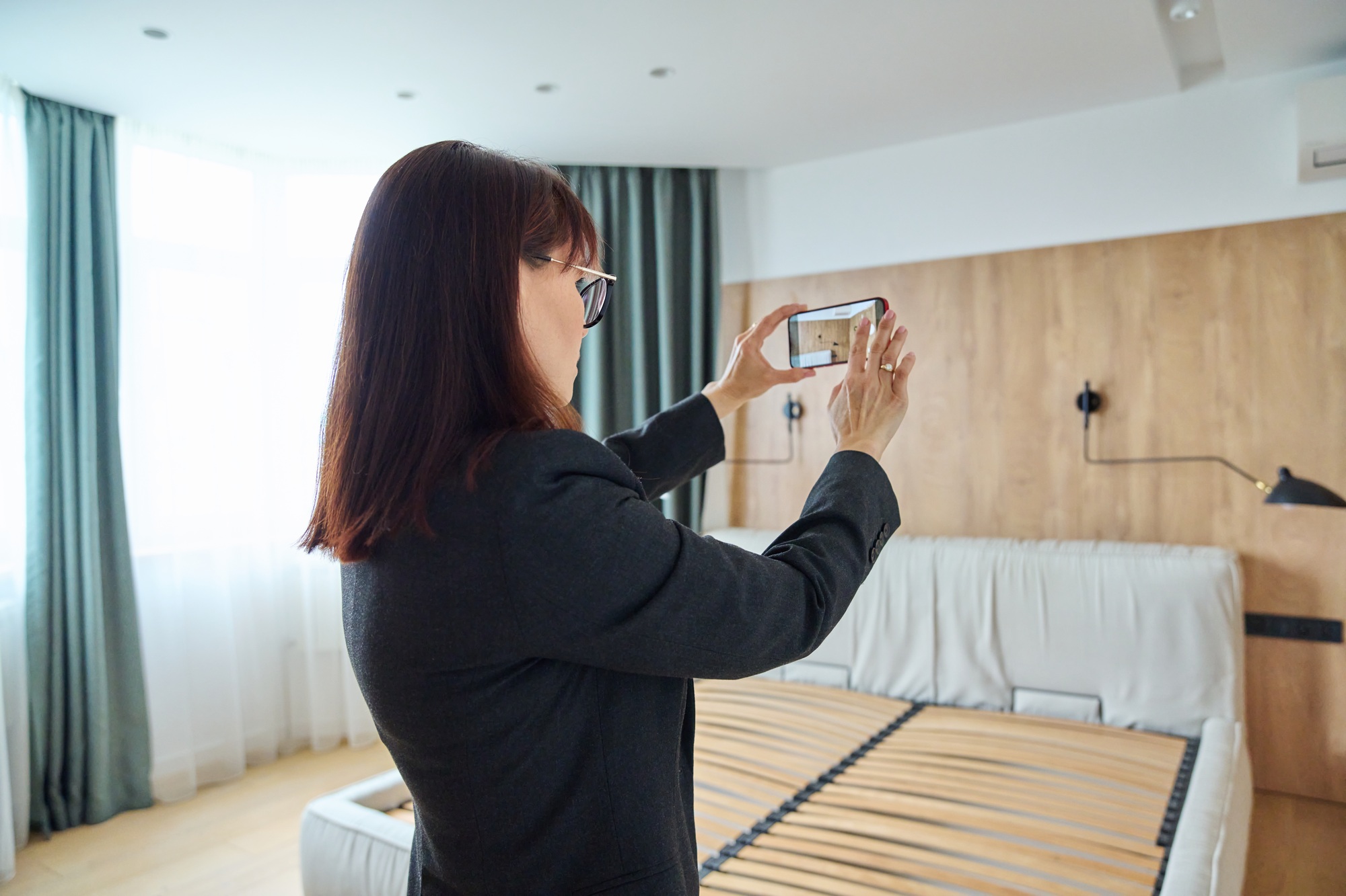 Woman real estate agent photographing furnished apartment